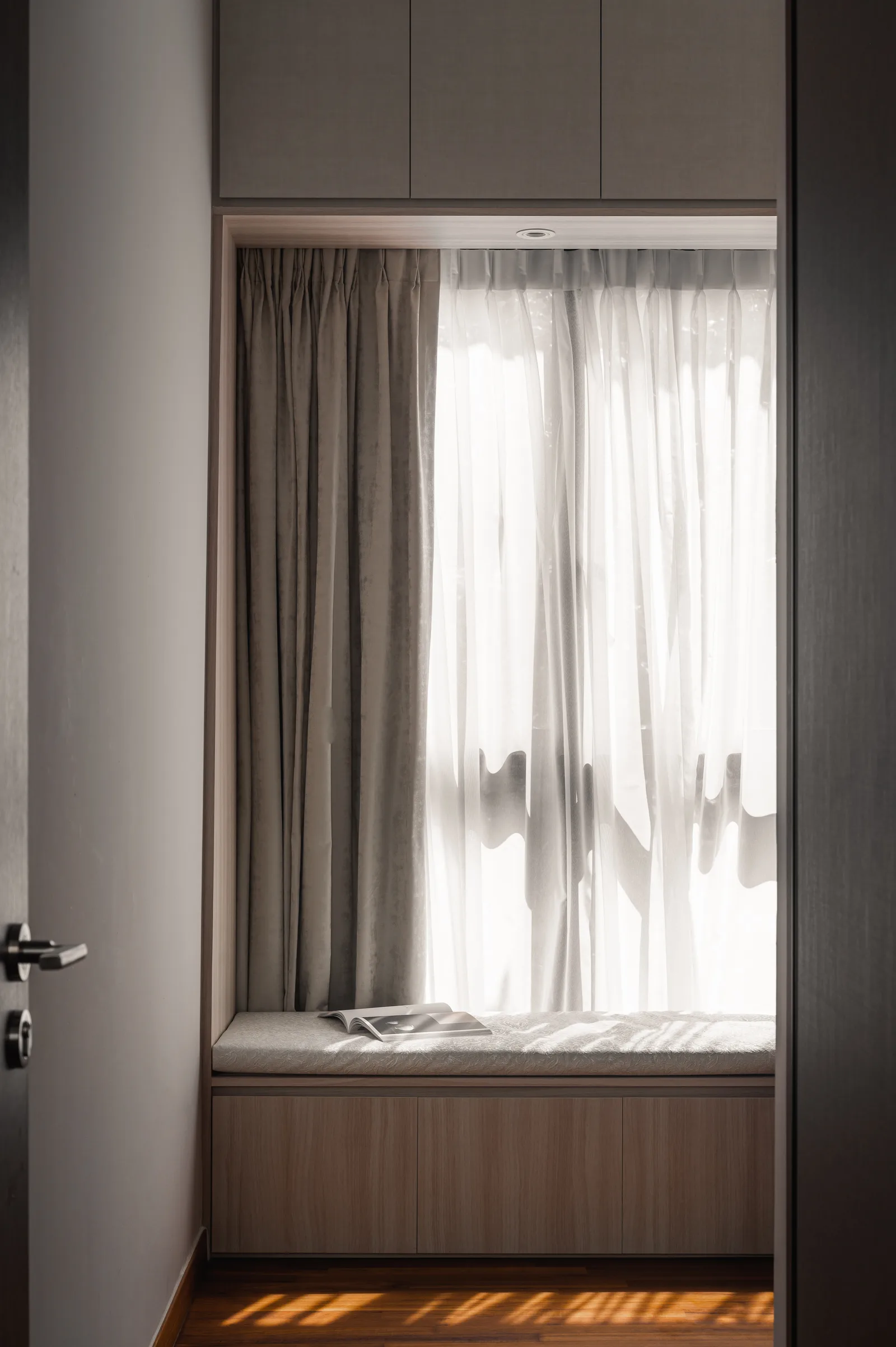 A curtained window seat in soft morning light